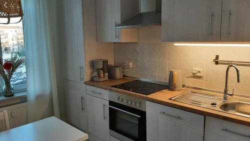 cocina con armarios blancos y fogones en Ferienwohnung Rudi, en Chemnitz