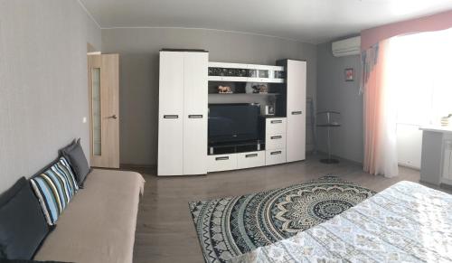 a living room with a tv in a white cabinet at Apartment on Spasskaya 61 in Kirov