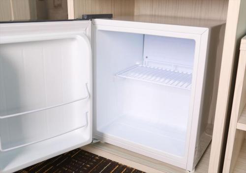 an empty white refrigerator with its door open at Hotel Wing International Chitose in Chitose