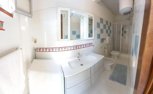 Un baño blanco con lavabo e inodoro. en Case Pescatori Villette, en Lampedusa