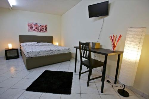 a bedroom with a bed and a desk with a computer at A Casa di Claudio in Catania