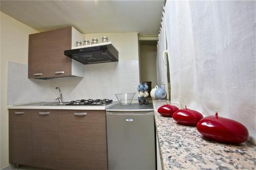 a kitchen with red balloons on a counter with a refrigerator at A Casa di Claudio in Catania