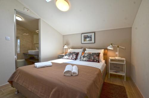 a bedroom with a bed with two shoes on it at App & Rooms Juraga in Bale