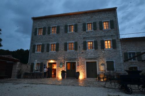 a man standing in front of a large stone building at App & Rooms Juraga in Bale