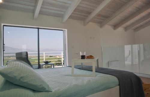 a bedroom with a bed and a large window at Case Playa Resort Balestrate in Balestrate