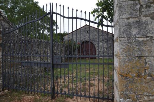 a black iron gate with a small house behind it at App & Rooms Juraga in Bale