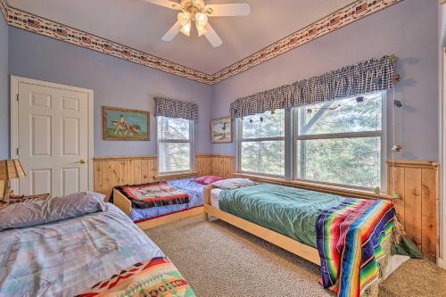 a bedroom with two beds and a ceiling fan at Wraparound Deck Woodland Cabin in Lake Arrowhead in Lake Arrowhead