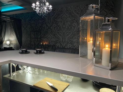 a table with glasses and candles in a room at Gray Apartment in Wrocław