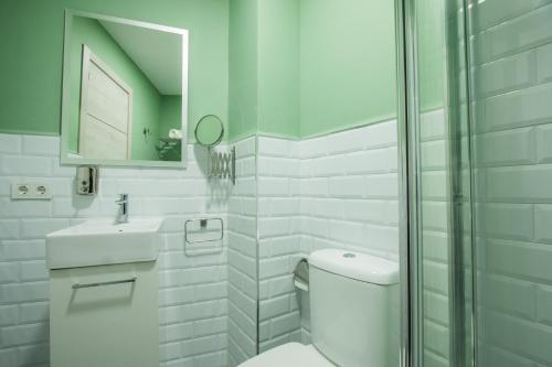 a white bathroom with a toilet and a mirror at Hostel SEA&DREAMS Calpe in Calpe