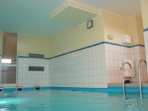 een groot zwembad met blauwe en witte tegels bij Haus Roland Wohnung 32 in Zinnowitz