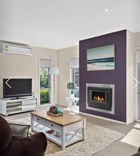 a living room with a fireplace and a tv at Redwood Delight in Cowes