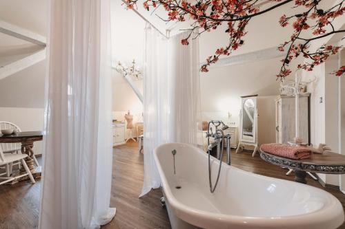 Resort Mlýn Černovice في Černovice: حوض استحمام أبيض في غرفة مع طاولة