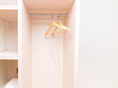 a room with white walls and a closet with hangers at Blitz Hotel Batam Centre in Batam Center