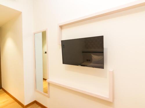 a flat screen tv on a wall in a room at Blitz Hotel Batam Centre in Batam Center