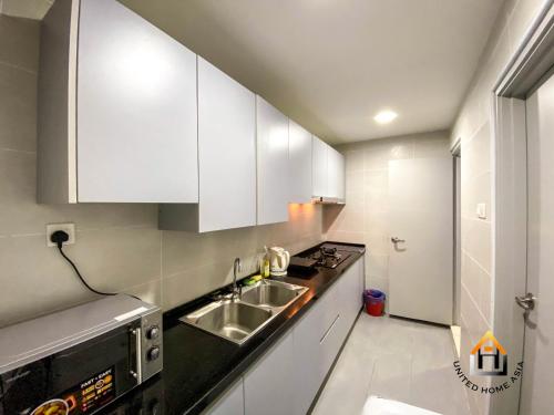 a kitchen with white cabinets and a sink at KSL DAYA HOT SPRING BY JK HOME in Johor Bahru