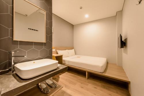 a bathroom with a white sink and a mirror at Yellow Bee Tanah Abang in Jakarta