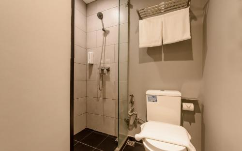 a bathroom with a toilet and a shower at Yellow Bee Tanah Abang in Jakarta