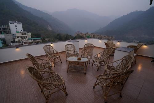 a group of chairs and tables on a balcony at Joey's Hostel Rishikesh in Rishīkesh