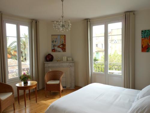 a bedroom with a bed and a table and chairs at Hotel Villa Les Cygnes in Nice