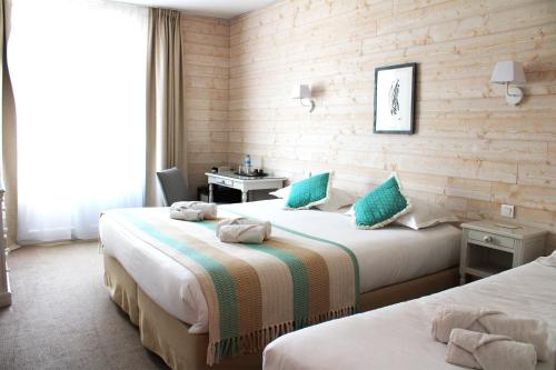 מיטה או מיטות בחדר ב-Hôtel Villa Flornoy Pornichet Baie de la Baule