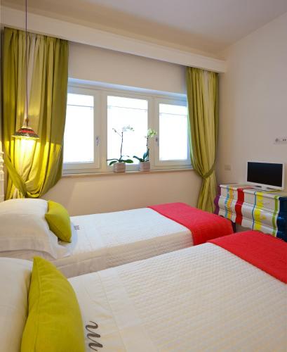 a bedroom with two beds and a window at Casa Marta Capri in Capri