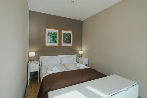 1 dormitorio con 1 cama con 2 mesas y 2 cuadros en la pared en Apartament Silence Triventi z Widokiem na Śnieżkę en Karpacz