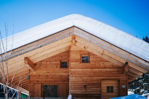 a log cabin with a snow covered roof at Karlshütte in Avelengo