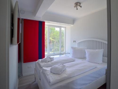 duże białe łóżko w pokoju z oknem w obiekcie Dünenresidenz Prora - Proradies Oberdeck B3-4-1 w mieście Binz