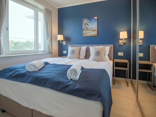 een slaapkamer met een groot bed met blauwe muren bij Dünenresidenz Prora - Ferienwohnung mit Meerblick, 1 Schlafzimmer und Balkon NP-401 in Binz