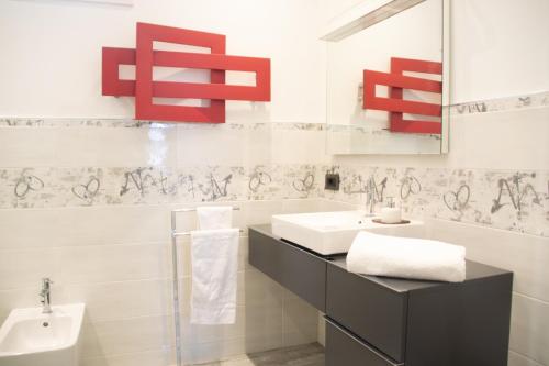 La salle de bains est pourvue d'un lavabo et d'un miroir. dans l'établissement Casa Dante - WelcHome, à Stresa