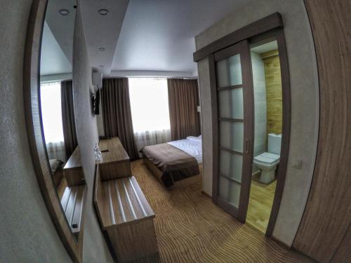 a room with a bedroom with a bed and a mirror at Hotel Druzhba in Kyiv