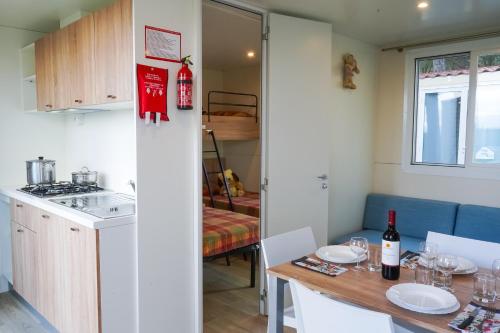 a kitchen with a sink, stove and refrigerator at Camping Village Mareblu in Marina di Cecina