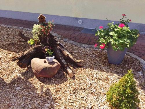 een tuin met een vogelhuisje en wat bloemen bij Ferienhaus Zschieck in Torno