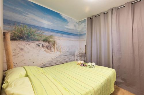 a bedroom with a bed with a painting of the beach at Apartman Lidija in Risika
