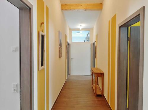 a hallway with yellow and white walls and a door at Torhaus Terra Nova in Elsterheide