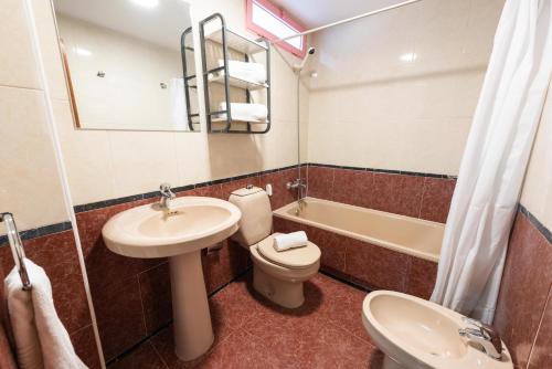 łazienka z umywalką, toaletą i wanną w obiekcie Apartamentos Nuevo México M 32 w mieście Calpe
