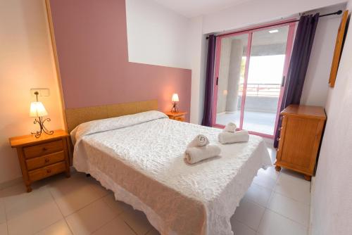 sypialnia z łóżkiem i ręcznikami w obiekcie Apartamentos Nuevo México M 32 w mieście Calpe