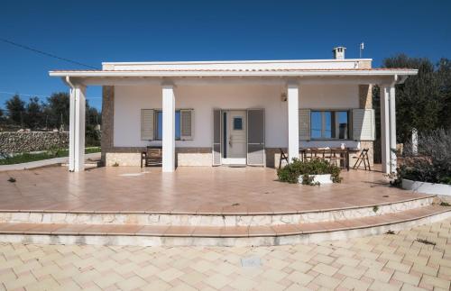 Casa blanca pequeña con patio grande en Villa Farniente San Gregorio, en Morciano di Leuca