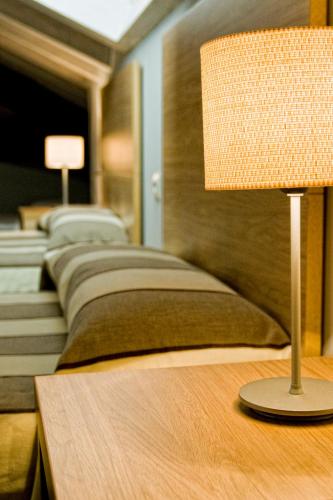a row of beds with a lamp on a table at Posada La Robla in La Cueva