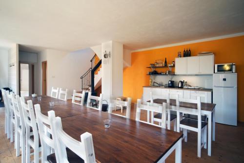 a dining room with a long table and white chairs at U Mišpule in Čížov