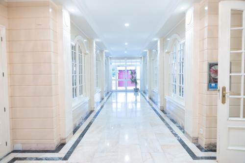 an empty hallway of a building with white walls and floors at Hotel Ramomar in Tomelloso