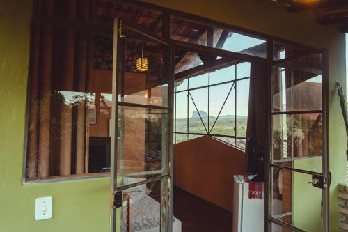 an open door to a room with a window at Vila Clara do Capão in Vale do Capao