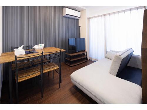 a room with a bed and a desk with a television at Coruscant Hotel NagasakiekiⅡ in Nagasaki