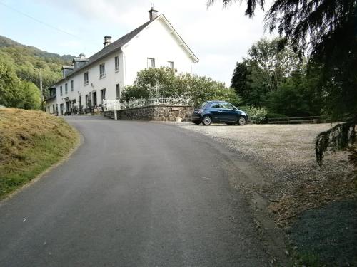 a car parked on the side of a road with a house at Les Sources in Saint-Jacques-des-Blats