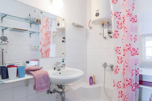 a white bathroom with a sink and a shower at APARTMA MILENA in Koper