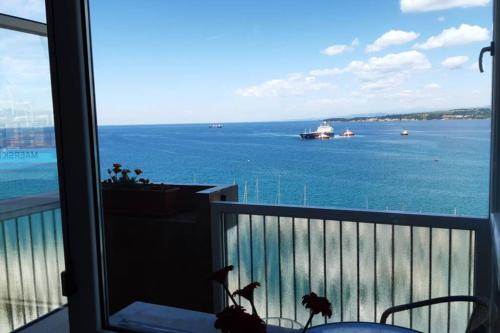 a balcony with a view of the ocean and a boat at APARTMA MILENA in Koper