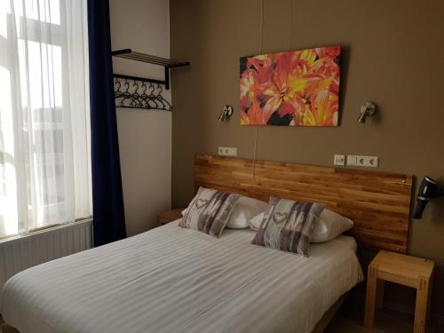 a bedroom with a bed with a wooden headboard at Hotel De Wilde Kriek in Valkenburg