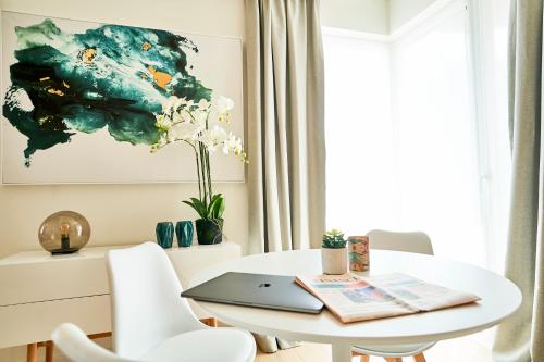 a white dining room table with a laptop on it at Diamant Studio in Brussels
