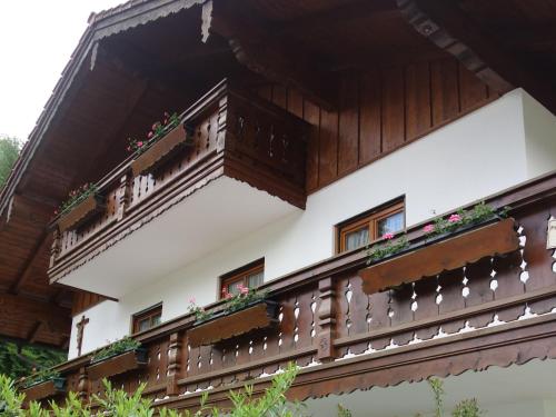 a building with wooden balconies and flowers on it at Spechthäusl in Bayerisch Gmain
