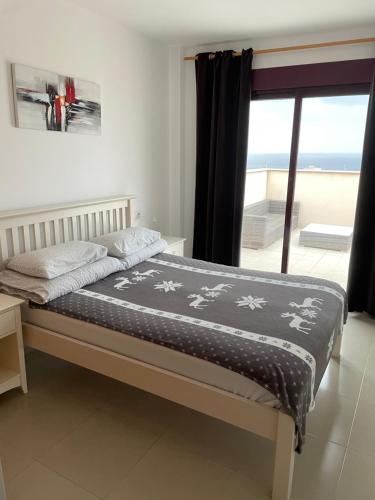 イスラ・プラナにあるSea View Apartament Isla Planaのビーチの景色を望むベッドルームのベッド1台